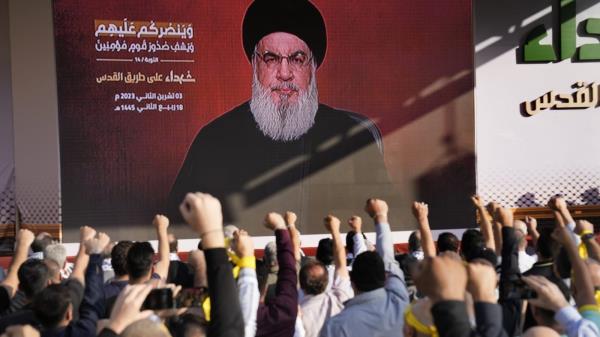 Supporters of the Iranian-backed Hezbollah group raise their fists and cheer as Hezbollah leader Sayyed Hassan Nasrallah appears via a video l<em></em>ink, during a rally to commemorate Hezbollah fighters who were killed in South Lebanon last few weeks while fighting against the Israeli forces, in Beirut, Lebanon, Friday, Nov. 3, 2023. (AP Photo/Hussein Malla)