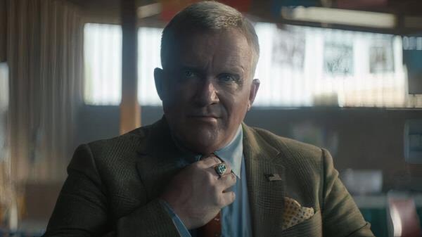 Anthony Michael Hall straightening his tie in Trigger Warning