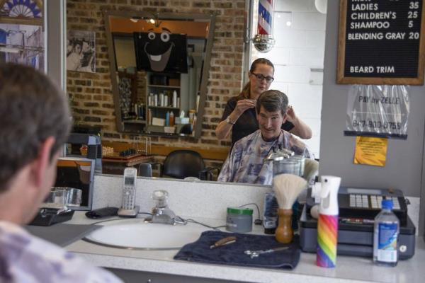 Highland Park resident Steve Nickel gets a haircut from Yelena Yorsh at Ravinia Barbershop, July 6, 2022, in Highland Park.